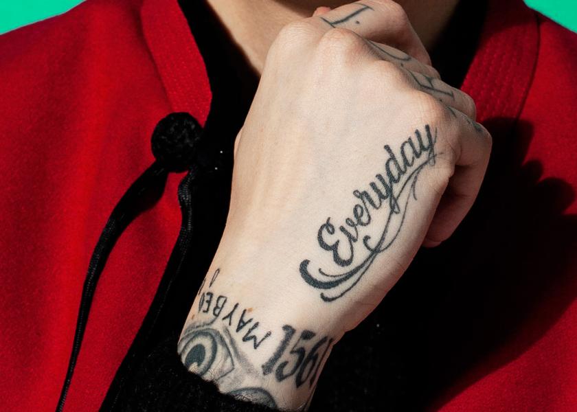 FOTOGRAFÍA DE MODA MOSTRANDO TATUAJE DE MANO Y CAPA