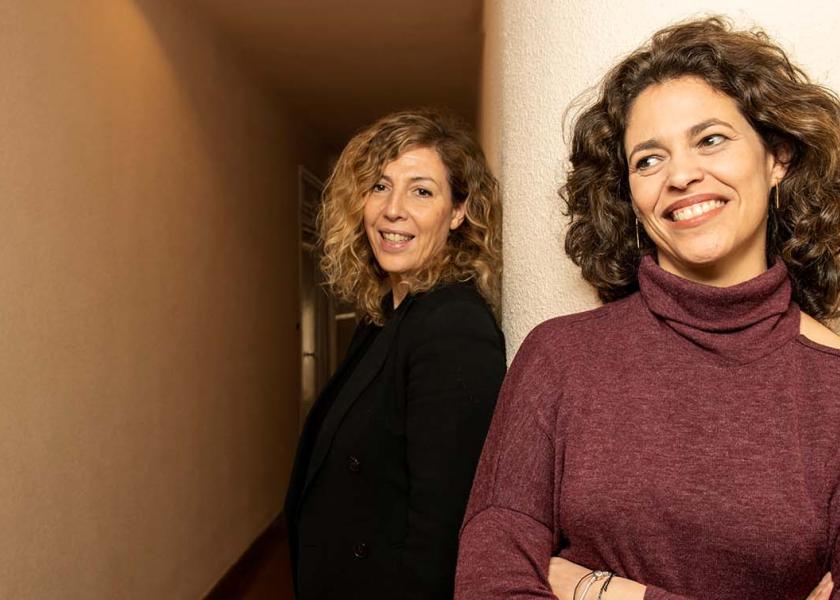 Yolanda Serrano (left) and Eva Leira (right) pose at the entrance of their office in Madrid.