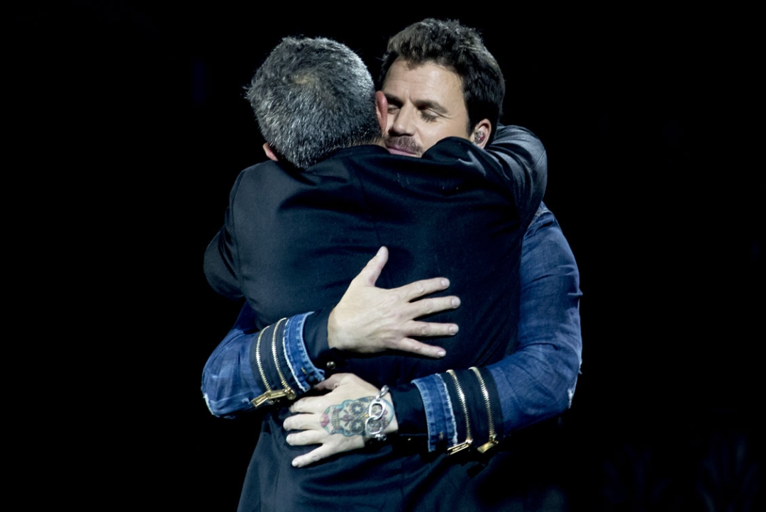 Alejandro Sanz y Dani Martín se abrazan sobre el escenario durante un concierto
