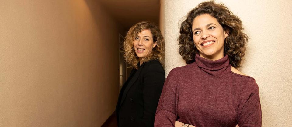 Yolanda Serrano (left) and Eva Leira (right) pose at the entrance of their office in Madrid.